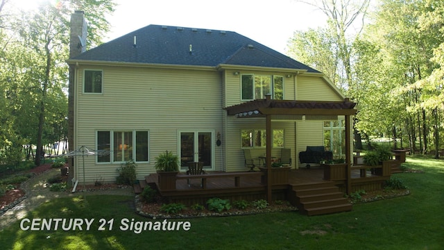 back of property featuring a chimney, a lawn, and a deck