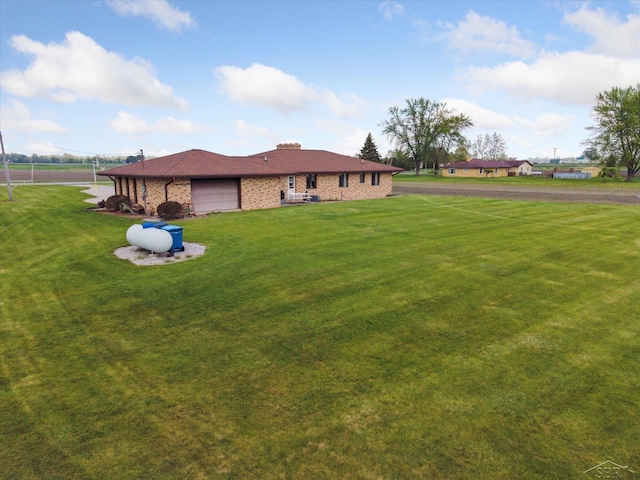 280 E Nebobish Rd, Essexville, MI 48732 - rear view of house with an attached garage, brick siding, and a yard