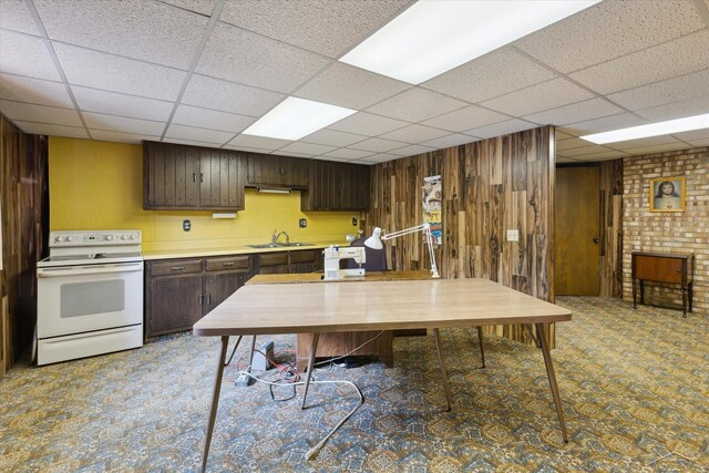 280 E Nebobish Rd, Essexville, MI 48732 - kitchen with white range with electric cooktop, wooden walls, a drop ceiling, dark brown cabinetry, and light countertops