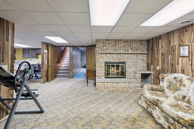 280 E Nebobish Rd, Essexville, MI 48732 - exercise room with a paneled ceiling, wood walls, carpet floors, and a fireplace