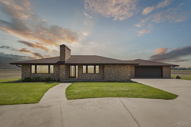 280 E Nebobish Rd, Essexville, MI 48732 - view of front facade with driveway, a yard, a chimney, a garage, and brick siding