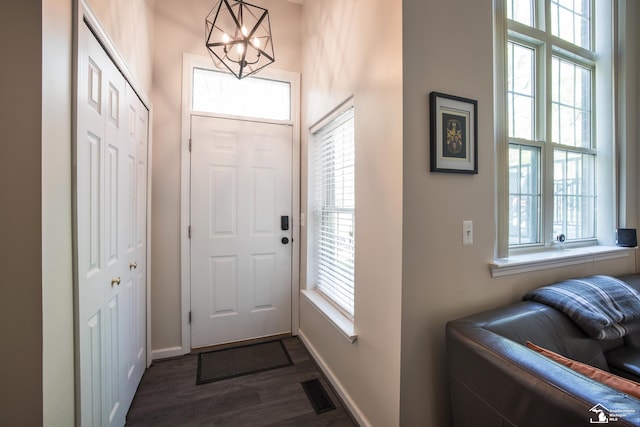 2827 Biddle Ave, Wyandotte, MI 48192 - entryway featuring a chandelier, dark wood-style flooring, and baseboards
