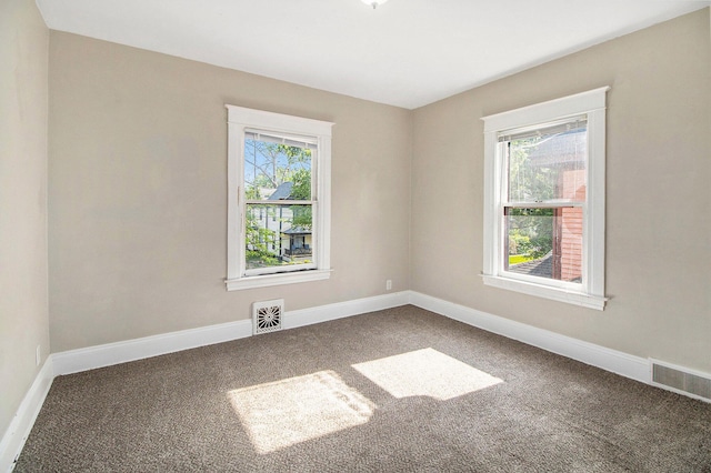 carpeted empty room featuring baseboards