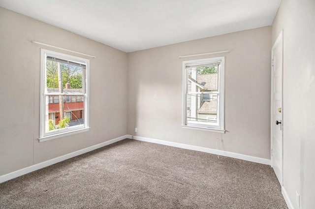 empty room with healthy amount of natural light, carpet floors, and baseboards