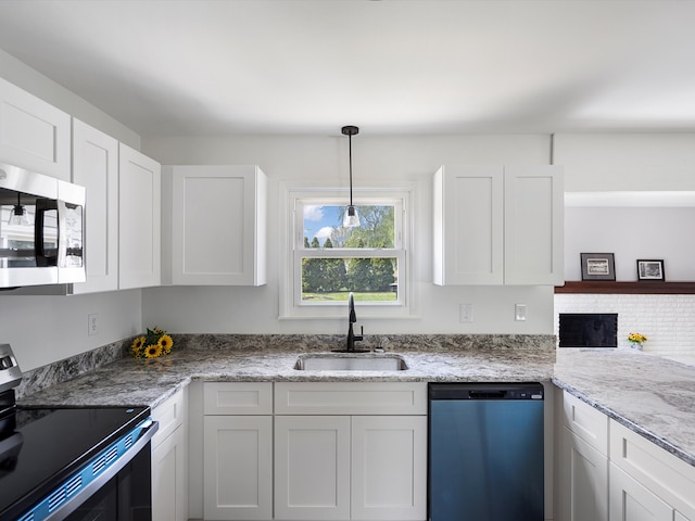600 Los Arboles Dr, Wolverine Lake, MI 48390 - kitchen featuring appliances with stainless steel finishes, a sink, white cabinets, decorative light fixtures, and light stone counters