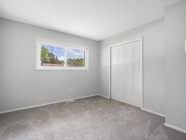 600 Los Arboles Dr, Wolverine Lake, MI 48390 - unfurnished bedroom with carpet flooring, baseboards, and a closet