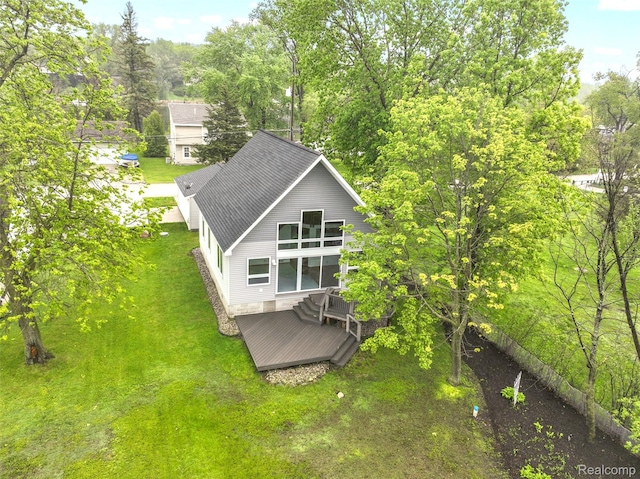 8844 Riverside Dr, Brighton, MI 48116 - rear view of house with a deck, a shingled roof, and a yard