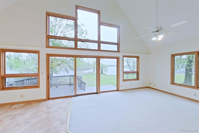 8844 Riverside Dr, Brighton, MI 48116 - unfurnished living room with high vaulted ceiling, baseboards, a ceiling fan, and a water view