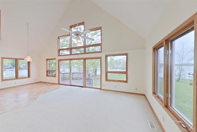 8844 Riverside Dr, Brighton, MI 48116 - unfurnished living room featuring high vaulted ceiling, a ceiling fan, light carpet, baseboards, and plenty of natural light