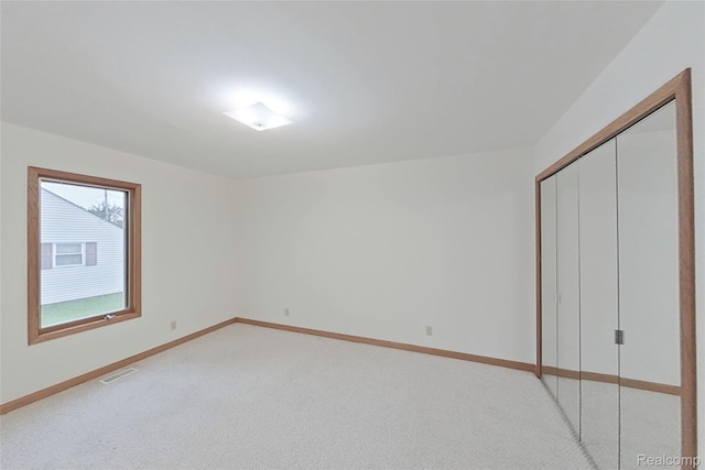 8844 Riverside Dr, Brighton, MI 48116 - unfurnished bedroom featuring light carpet, a closet, and baseboards