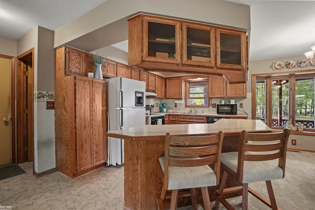 3641 Timber Ridge Dr, Metamora, MI 48455 - kitchen with freestanding refrigerator, light carpet, black microwave, range with electric cooktop, and light countertops