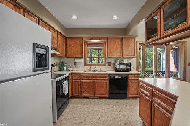 3641 Timber Ridge Dr, Metamora, MI 48455 - kitchen with black appliances, a sink, light countertops, under cabinet range hood, and light carpet