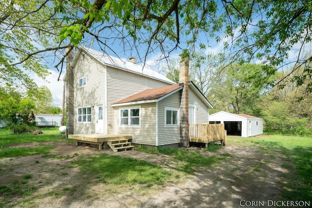 3188 E Stage Rd, Ionia, MI 48846 - rear view of property featuring a deck, an outdoor structure, a detached garage, and a chimney