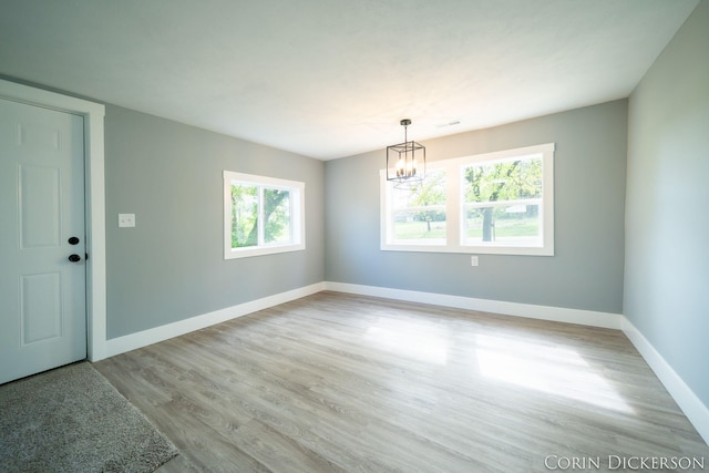 3188 E Stage Rd, Ionia, MI 48846 - unfurnished room featuring a chandelier, light wood-style flooring, and baseboards