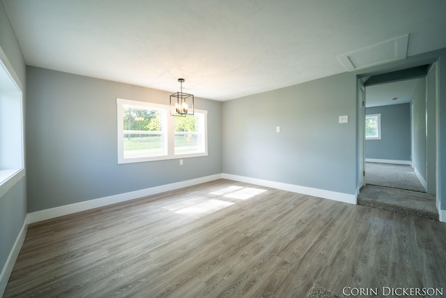 3188 E Stage Rd, Ionia, MI 48846 - spare room with wood finished floors, baseboards, and a chandelier