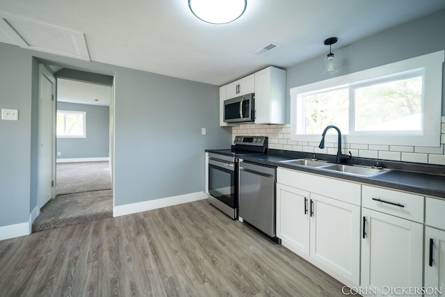 3188 E Stage Rd, Ionia, MI 48846 - kitchen with stainless steel appliances, a sink, dark countertops, and decorative backsplash
