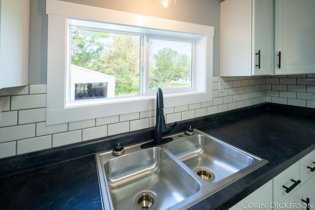 3188 E Stage Rd, Ionia, MI 48846 - kitchen view of a sink, backsplash, dark countertops, and white cabinets