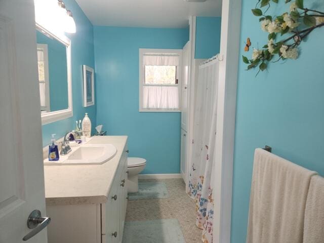 1788 W Beaver Rd, Bitely, MI 49309 - bathroom featuring toilet, vanity, baseboards, and a shower with shower curtain