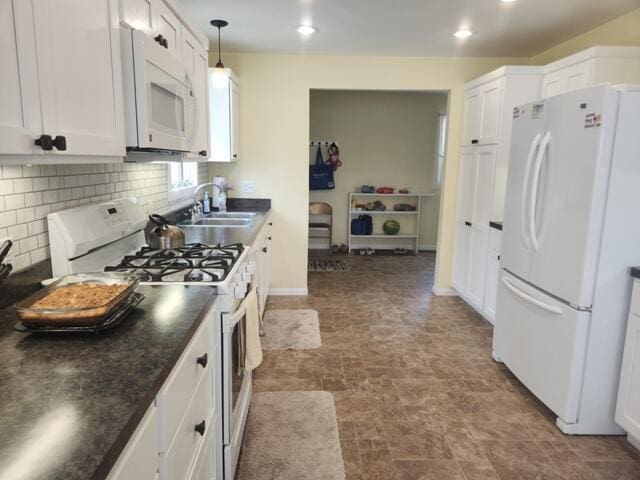 1788 W Beaver Rd, Bitely, MI 49309 - kitchen with white appliances, a sink, dark countertops, white cabinetry, and recessed lighting