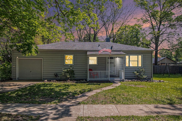 view of front of home featuring an attached garage, covered porch, driveway, and roof with shingles