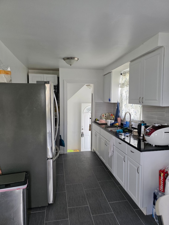 8845 Faust Ave, Detroit, MI 48228 - kitchen featuring freestanding refrigerator, a sink, decorative backsplash, dark countertops, and white cabinets