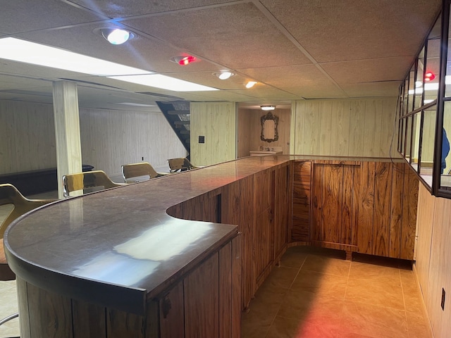 5250 Hardwoods Dr, West Bloomfield, MI 48323 - indoor dry bar featuring wood walls, light tile patterned floors, and stairway