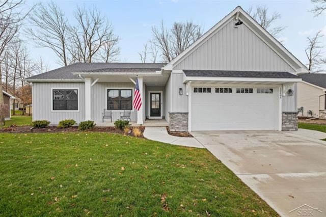 12405 Northway Pkwy, Freeland, MI 48623 - view of front facade with covered porch, an attached garage, concrete driveway, a front yard, and a shingled roof
