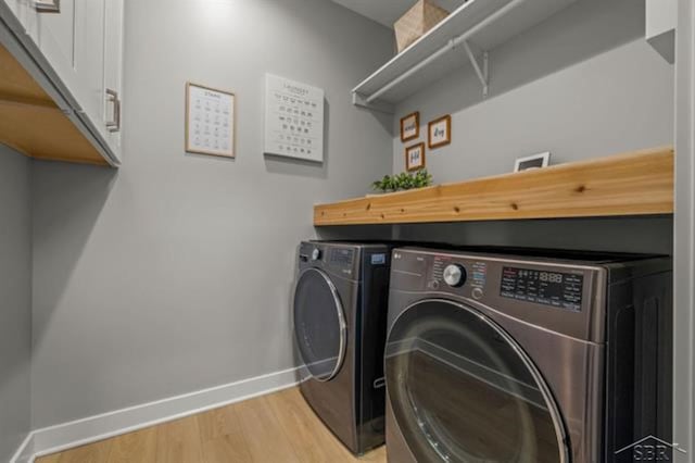 12405 Northway Pkwy, Freeland, MI 48623 - laundry room featuring baseboards, washing machine and clothes dryer, light wood finished floors, and cabinet space