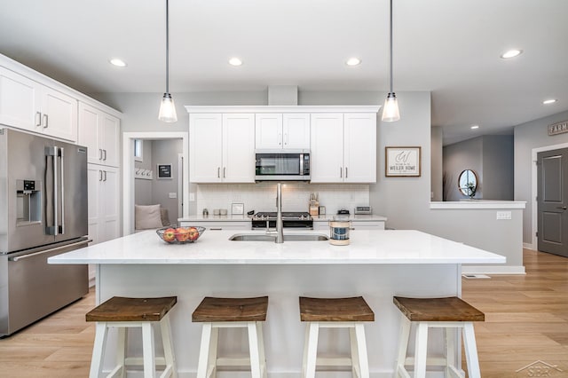 12405 Northway Pkwy, Freeland, MI 48623 - kitchen featuring appliances with stainless steel finishes, a sink, recessed lighting, tasteful backsplash, and light wood-type flooring
