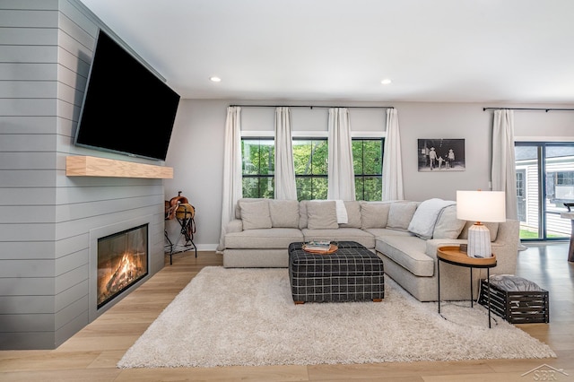 12405 Northway Pkwy, Freeland, MI 48623 - living room with recessed lighting, a glass covered fireplace, wood finished floors, and baseboards