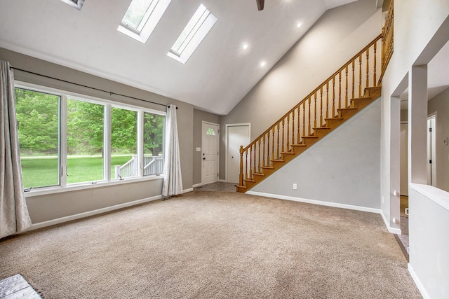 7512 Trophy Ct, Grass Lake, MI 49240 - unfurnished living room featuring carpet floors, high vaulted ceiling, a skylight, stairs, and baseboards