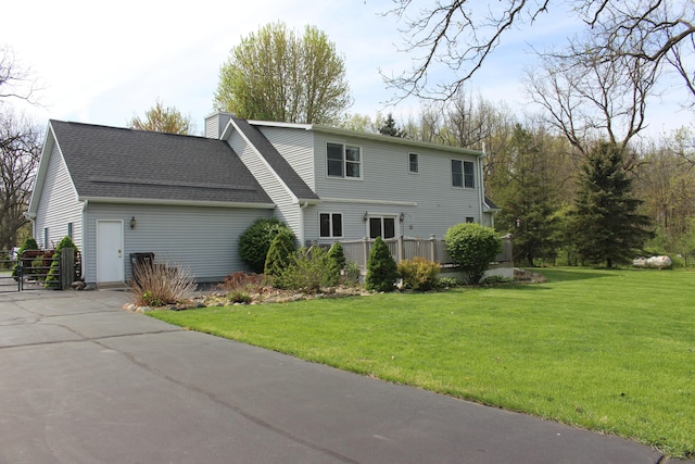7512 Trophy Ct, Grass Lake, MI 49240 - view of front of home featuring a front yard, a chimney, and roof with shingles