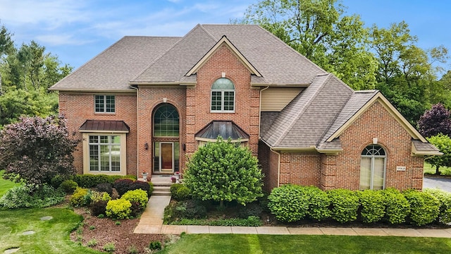 9968 Tuscany Valley Way S, Lyon, MI 48178 - traditional home with brick siding, a shingled roof, and a front yard