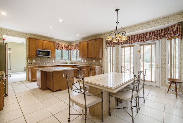 9968 Tuscany Valley Way S, Lyon, MI 48178 - kitchen featuring stainless steel appliances, a kitchen island, light tile patterned floors, brown cabinets, and recessed lighting