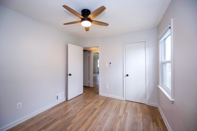 5875 S Madison St, Taylor, MI 48180 - unfurnished bedroom with multiple windows, baseboards, light wood-style flooring, and a ceiling fan