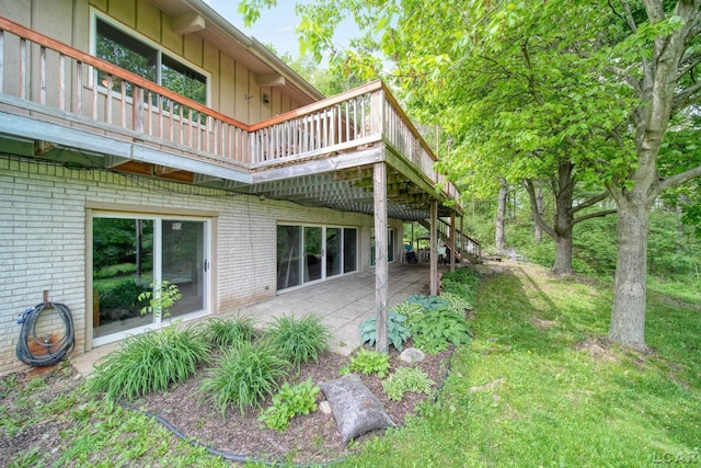 3224 Thornhill Dr, Adrian, MI 49221 - view of side of home featuring brick siding, a wooden deck, stairs, and a patio area