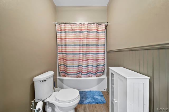 3224 Thornhill Dr, Adrian, MI 49221 - bathroom featuring wood finished floors, shower / tub combo, a wainscoted wall, and toilet