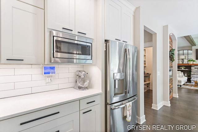 6326 Eaglewood Dr, Hudsonville, MI 49426 - kitchen featuring stainless steel appliances, tasteful backsplash, dark wood-type flooring, white cabinetry, and baseboards