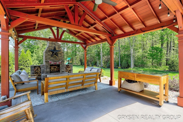 6326 Eaglewood Dr, Hudsonville, MI 49426 - view of patio / terrace featuring an outdoor living space with a fireplace, a gazebo, a ceiling fan, and a view of trees