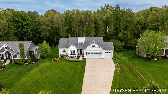 6326 Eaglewood Dr, Hudsonville, MI 49426 - modern inspired farmhouse featuring a garage, driveway, a front yard, board and batten siding, and a wooded view