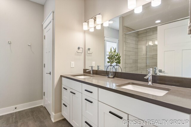 6326 Eaglewood Dr, Hudsonville, MI 49426 - full bathroom featuring wood finished floors, a stall shower, double vanity, and baseboards