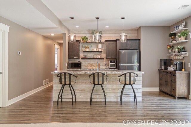 6326 Eaglewood Dr, Hudsonville, MI 49426 - kitchen featuring open shelves, appliances with stainless steel finishes, wood finished floors, a kitchen bar, and dark brown cabinets