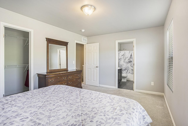 carpeted bedroom featuring baseboards, a closet, connected bathroom, and a spacious closet