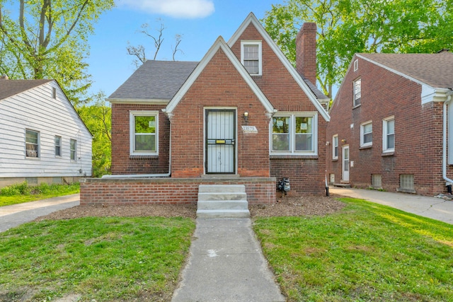 13575 Rutherford St, Detroit, MI 48227 - tudor-style house with a chimney, brick siding, and a front lawn