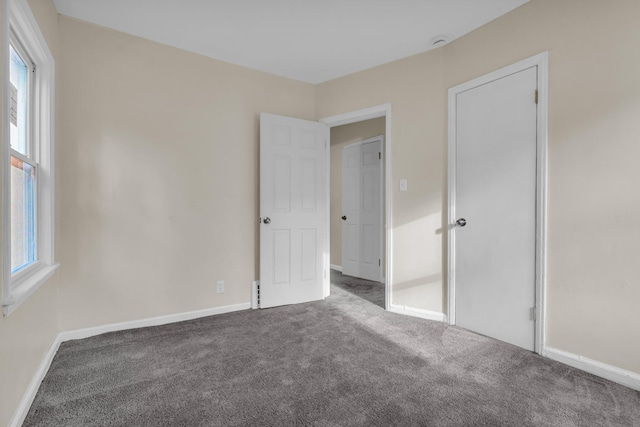 13575 Rutherford St, Detroit, MI 48227 - unfurnished bedroom featuring carpet floors, multiple windows, and baseboards