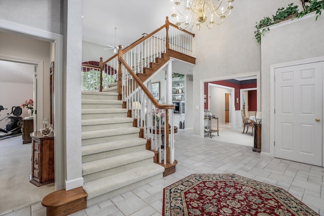 30465 Stonegate Dr, Franklin, MI 48025 - entrance foyer with stairway, a towering ceiling, ceiling fan, a chandelier, and baseboards