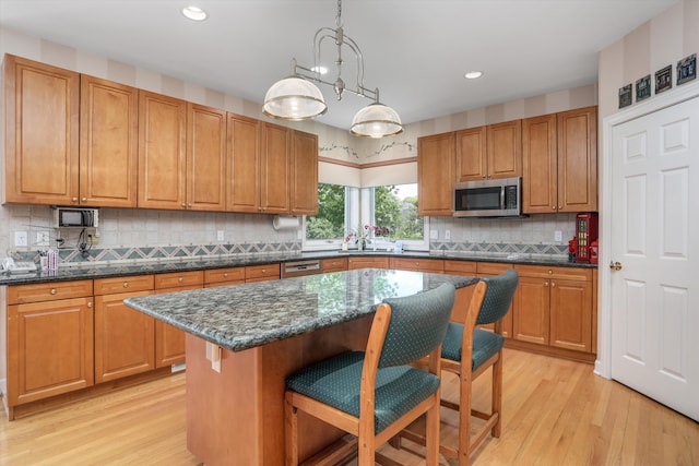 30465 Stonegate Dr, Franklin, MI 48025 - kitchen with stainless steel microwave, light wood-type flooring, a breakfast bar, recessed lighting, and backsplash