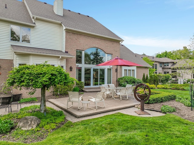 30465 Stonegate Dr, Franklin, MI 48025 - back of property with a patio, a chimney, a lawn, brick siding, and roof with shingles