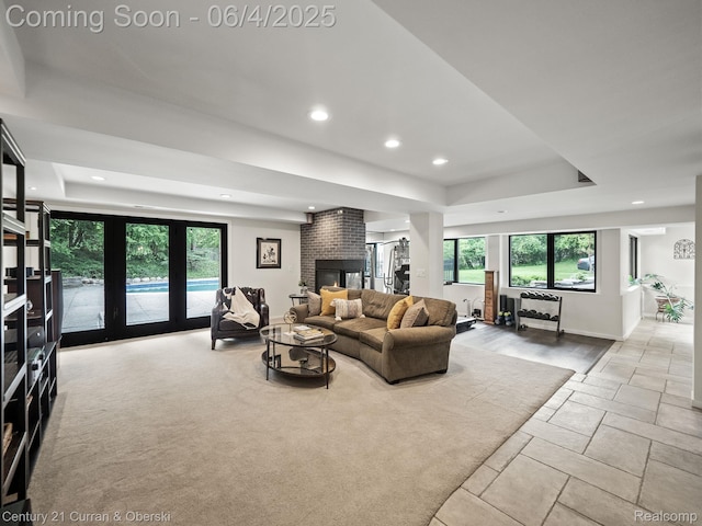 1985 Lone Pine Rd, Bloomfield Hills, MI 48302 - living area featuring a tray ceiling, recessed lighting, a brick fireplace, and stone tile flooring