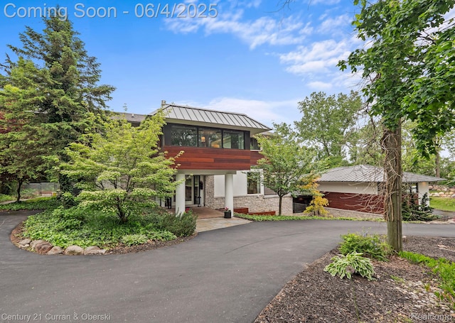 1985 Lone Pine Rd, Bloomfield Hills, MI 48302 - view of front of house featuring stone siding, asphalt driveway, metal roof, and a standing seam roof